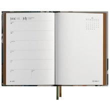 Open planner showing a monthly layout with a floral design on the cover
